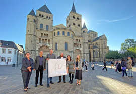 Gruppenbild vor dem Dom, die Beteiligten halten ein Plakat der Pufferzone in Händen