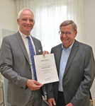 Oberbürgermeister Wolfram Leibe präsentiert die Urkunde für Gerhard Thesen zur Versetzung in den Ruhestand. 