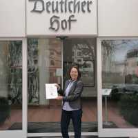 Andrea Weber mit der gerade verliehenen Urkunde vor ihrem Hotel Deutscher Hof.