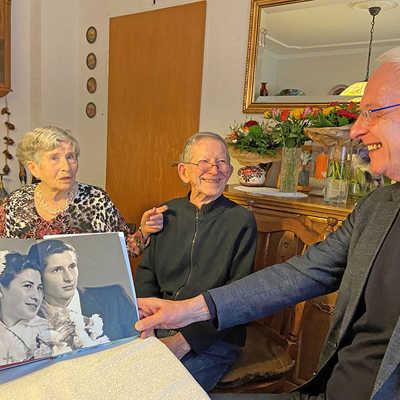 OB Wolfram Leibe (rechts) schaut gemeinsam mit Ludwig und Anna Schmitt ein Fotoalbum, das auch ein Hochzeitfoto der beiden aus dem Jahr 1954 zeigt.