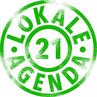 Das Logo der Lokalen Agenda 21 besteht aus zwei Kreisen. Im inneren Kreis steht 21, im äußeren Kreis steht Lokale Agenda. Das Logo ist grün.