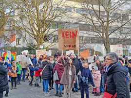 Teilnehmerinnen und Teilnehmer einer Demosntration halten Plakate und Transparente