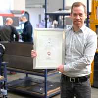 Henning Schlöder mit der Auszeichnung in seinem Betrieb S&D Blechtechnologie GmbH