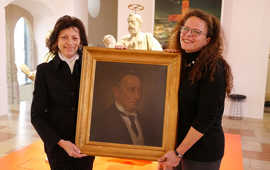 Petra Schellenberg (l.) übergibt Dr. Bärbel Schulte vom Stadtmuseum ein Porträt von Louis Schellenberg