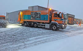 Ein Laster der Müllabfuhr manövriert bei Schneetreiben
