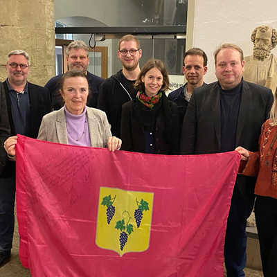Bürgermeisterin Elvira Garbes, Vertreter der Stadtratsfraktionen und Mitglieder der Deutsch-Ukrainischen Gesellschaft präsentieren die Fahne der neuen Partnerstadt Isjum. 