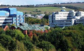 Der Campus der Universität Trier prägt den Stadtteil Tarforst. Im Hintergrund Häuser des alten Ortskerns. 