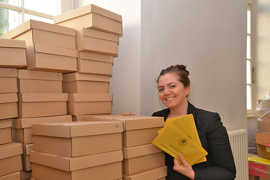 Die Leiterin des Wahlamts Maylin Müllers mit Paketen voller Umschläge für Stimmzettel, die am 26. Mai gebraucht werden.